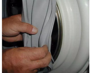 Специалист проводит замену резинки стиральной машины